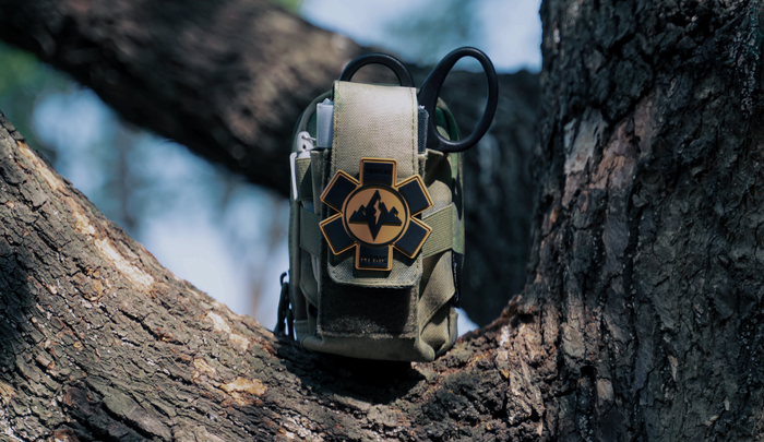 A low-profile FlareSyn Micro medical pouch in Wolf Grey placed next to a passport and boarding pass on a clean airport lounge table.
