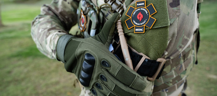 Close-up of CAT tourniquet and tactical gloves on gear